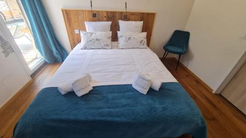 a large bed in a room with a blue blanket at Domaine de Rozan - Col de Porte, Chartreuse - Grenoble in Sarcenas
