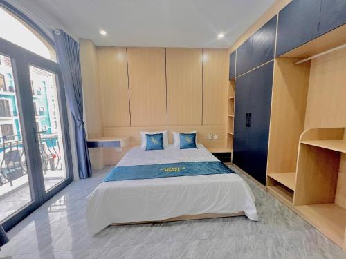a bedroom with a large bed with blue pillows at Anna Belle Đồi Rồng Hotel - Homestay chuỗi HPT Home Hải Phòng in Kon Rung (1)