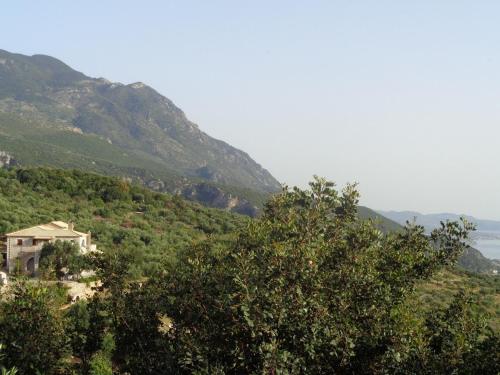 a view of a mountain with a house and trees at Menina Farm Kalamata Countryside in Perivolákia