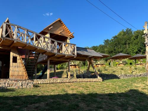 a log house with a deck on the side of it at Pensiunea Valea Branzei in Năneşti