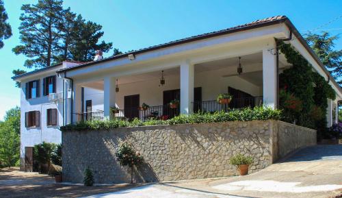 a white house with a stone wall at Villa Curcio casa vacanze 