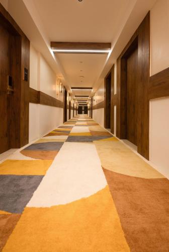 an empty hallway with a striped floor in a building at Royal Plaza Inn by RAK Rooms, Calicut in Kozhikode
