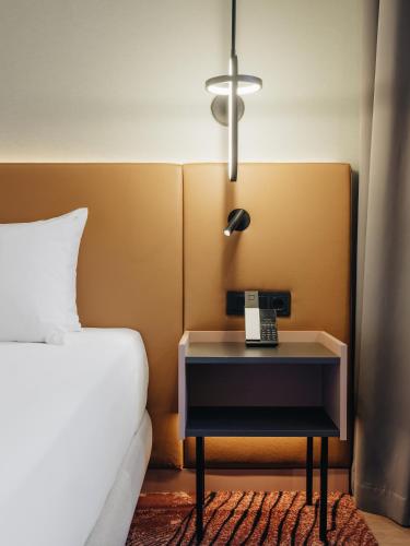 a bedroom with a bed and a table with a phone on it at Hyatt Place Tallinn in Tallinn