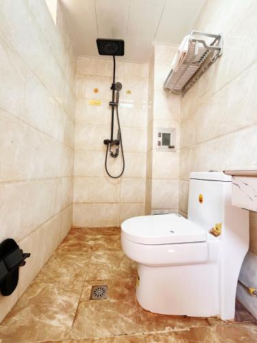 a bathroom with a toilet and a shower at MAXHILL inn悦季时光酒店 in Jinghong
