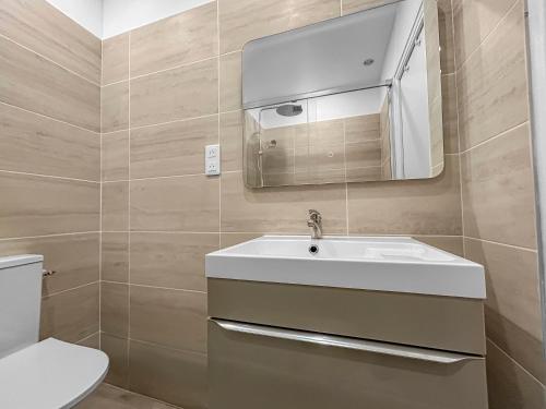 a bathroom with a white sink and a mirror at Confort et charme en plein Brest, vue sur la rade in Brest