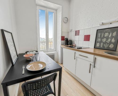 une cuisine avec une table avec une assiette dessus dans l'établissement Confort et charme en plein Brest, vue sur la rade, à Brest