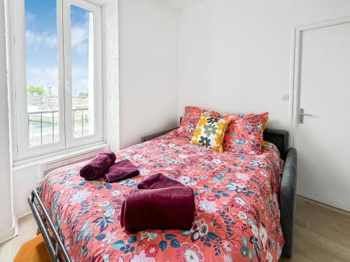 a bedroom with a bed with a colorful comforter and pillows at Confort et charme en plein Brest, vue sur la rade in Brest