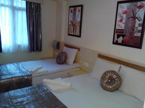 a small room with two beds and a window at Olimpiyat Hotel Izmir in Izmir