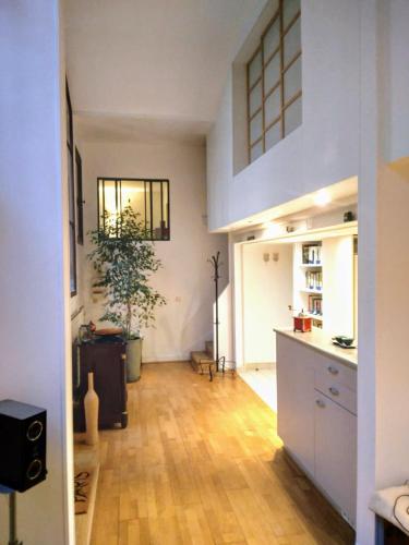 Il comprend une cuisine avec des placards blancs et du parquet. dans l'établissement Loft with view on a quiet garden, Parisian Charm, à Paris