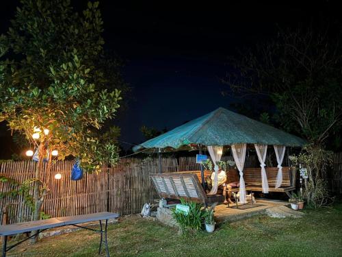 un gazebo con tavolo e panca di notte di Allena - Cabin, Farm and Camp House in Alfonso Cavite ad Alfonso