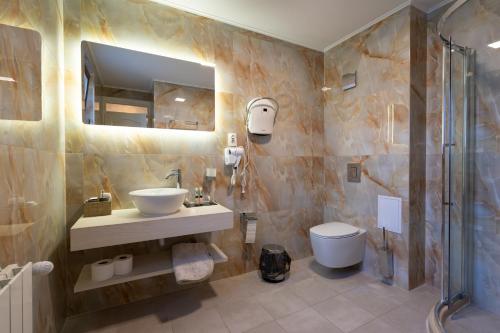 a bathroom with a sink and a toilet and a mirror at Casa MT - Boutique Villa in Gabrovo