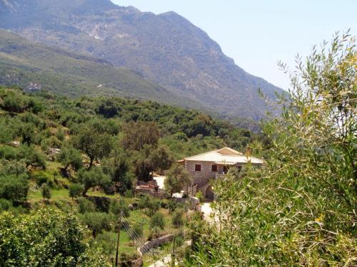 a house in a field with a mountain in the background at Menina Farm Kalamata Countryside in Perivolákia