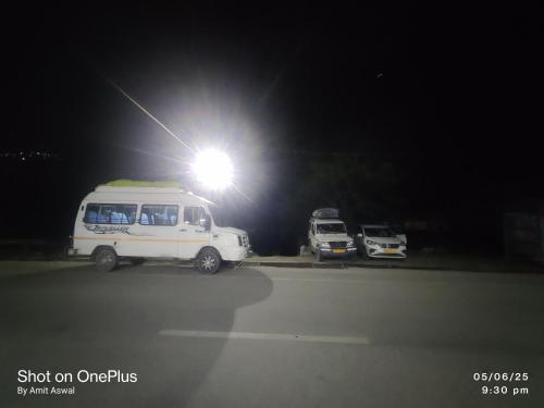 a white van parked under a light at night at Mansi Hotel and restaurant in Chamoli