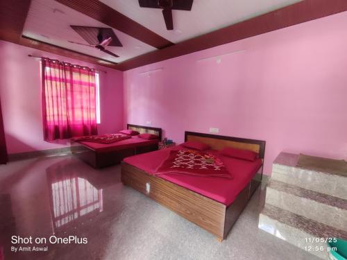 two beds in a room with pink walls at Mansi Hotel and restaurant in Chamoli
