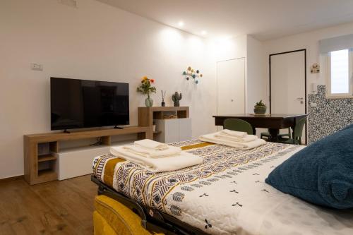 ein Schlafzimmer mit einem Bett und einem Flachbildfernseher in der Unterkunft La casetta di Nina in Castellana Grotte