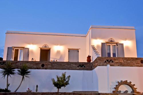 a white house with a fence in front of it at Crystal View in Triandáros