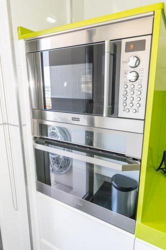 a microwave oven in a kitchen with a green wall at Apartamento Vistas de Rajamanta | +Terraza, Playa + Garaje in Barbate