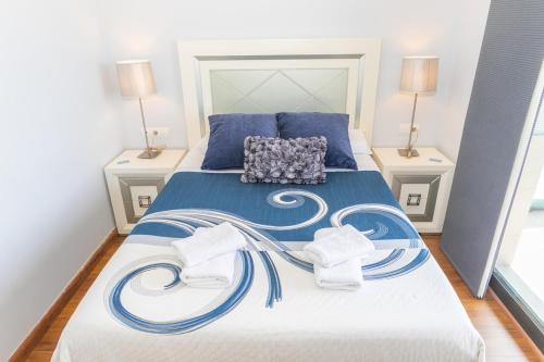 a bedroom with a blue and white bed with two lamps at Apartamento Vistas de Rajamanta | +Terraza, Playa + Garaje in Barbate
