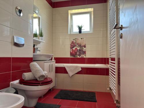 a red and white bathroom with a toilet and a sink at Avantgarden Studio Brasov in Braşov
