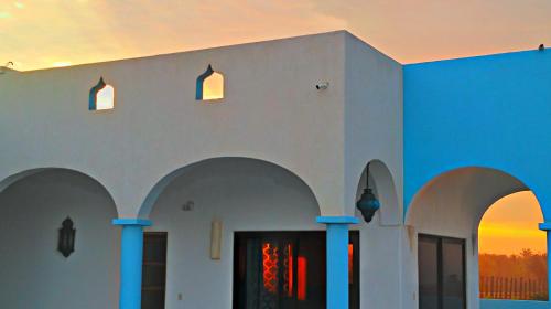 a building with arches and a sunset in the background at Villa Star of the Sea in Barra de Navidad