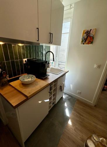 une cuisine avec un comptoir et un évier dans l'établissement Appartement niché au cœur de Montmartre, à Paris