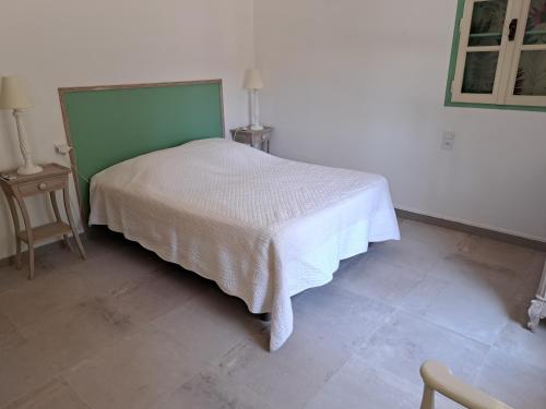 - une chambre avec un lit blanc et une tête de lit verte dans l'établissement VILLA T2, à Gréoux-les-Bains