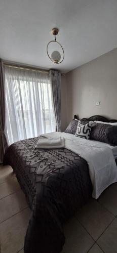 a bedroom with a large bed and a window at The DeeLight Stay in Nairobi