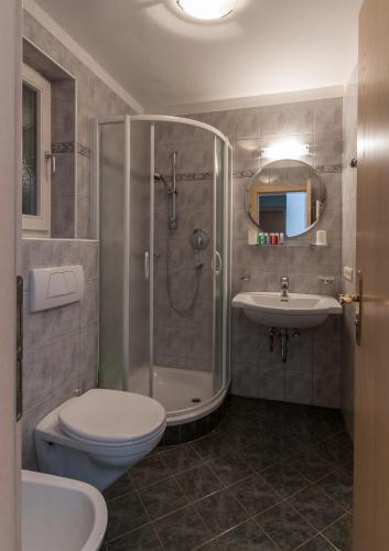 a bathroom with a shower and a toilet and a sink at Villa Haunold in Sesto