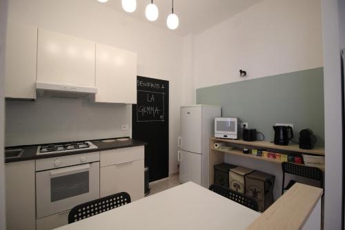 a small kitchen with a table and a refrigerator at Appartamento La Gemma in Parma