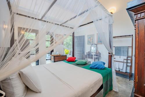 a bedroom with a bed with a canopy at Wasantha Garden Hotel Restaurant & Ayurvedic Treatment in Weligama
