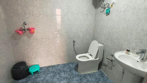 une salle de bain avec toilettes et lavabo dans l'établissement Luxuries Stay in Noida with Swimming Pool #Night Club #Party #Cafe at Mall - GHUMLOO, à Noida