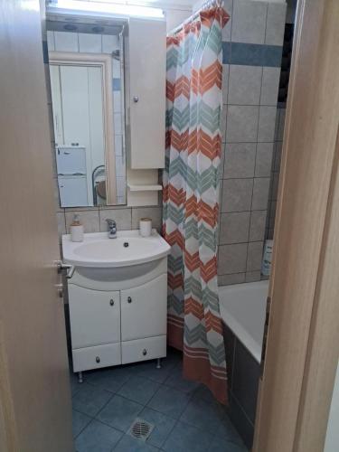 a bathroom with a sink and a shower curtain at Makis rooms A in Mesolongion