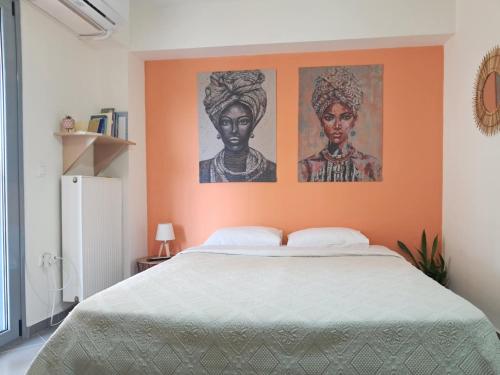 a bedroom with an orange wall with two posters at Makis rooms A in Mesolongion