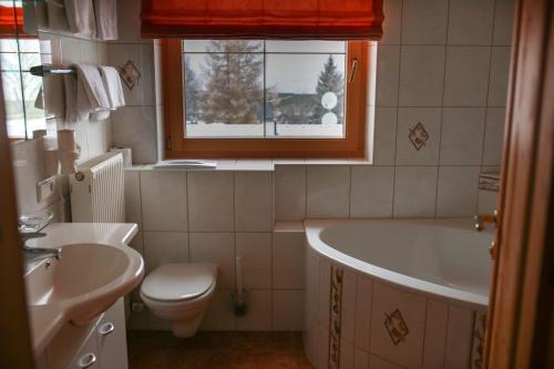 a bathroom with a tub and a toilet and a sink at Pension Sonnenheim in Schönberg im Stubaital