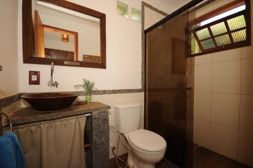 La salle de bains est pourvue de toilettes, d'un lavabo et d'un miroir. dans l'établissement Buzios Casa 1, à Búzios