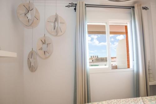 ein Schlafzimmer mit drei Tellern an der Wand und einem Fenster in der Unterkunft Casa Consorcio | +Terraza y Paseo Marítimo in Barbate