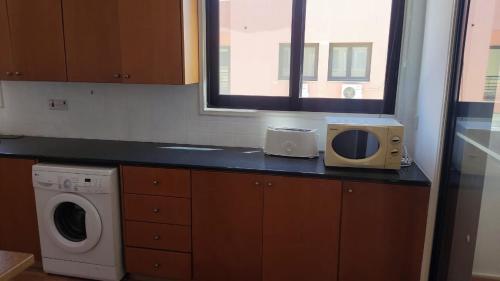 a kitchen with a counter with a microwave and a window at 3-bedroom penthouse in Larnaka