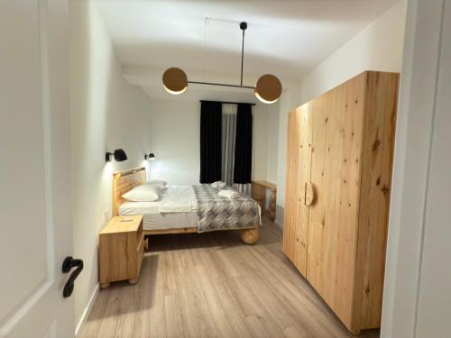 a bedroom with a bed and a wooden door at Kvariati House in Kvariati