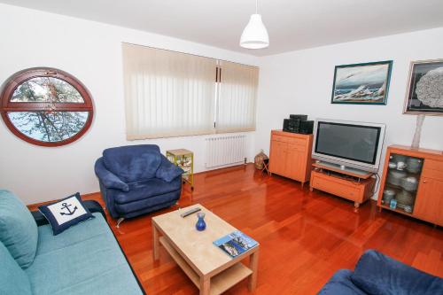 a living room with a blue couch and a tv at Apartman Lavanda in Kali
