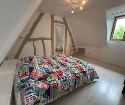 una camera da letto con un letto grande in una mansarda di Charming house surrounded by nature a Courtonne-la-Meurdrac