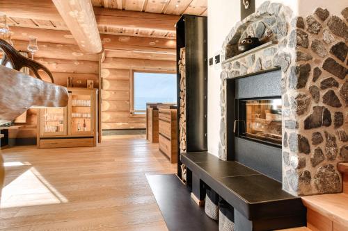 a living room with a fireplace in a log house at Sonnenchalet Bomhuesle in Dalaas