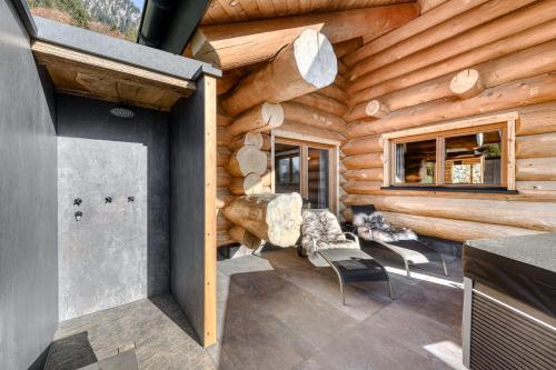 a log cabin with chairs and a fireplace at Sonnenchalet Bomhuesle in Dalaas
