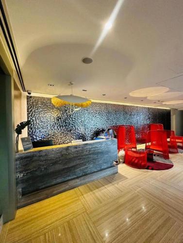 a restaurant with red chairs and a stone wall at Novotel Hotel Residences Manila by AMORE Suites in Manila