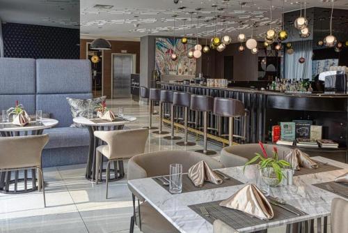 a restaurant with tables and chairs and a bar at Novotel Hotel Residences Manila by AMORE Suites in Manila