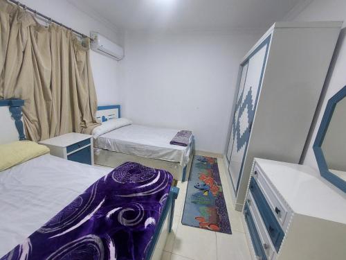 Zimmer mit 2 Betten und einer lila Matratze in der Unterkunft شقة مفروشة للإيجار اليومي في كمبوند جاردينيا سيتي in Kairo