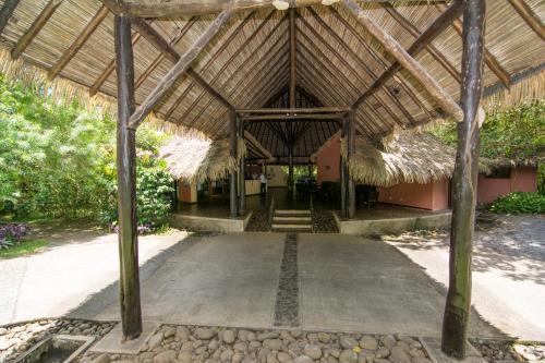 a building with a thatched roof and a driveway at Sarapiquis Rainforest Lodge in Sarapiquí