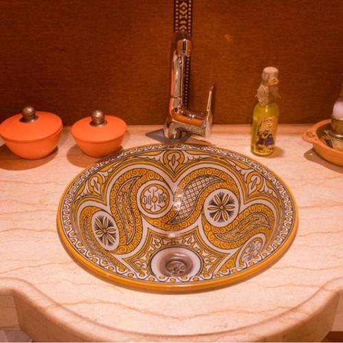a bathroom sink with a flowered pattern on it at Sahara Soul luxury Camp in Merzouga