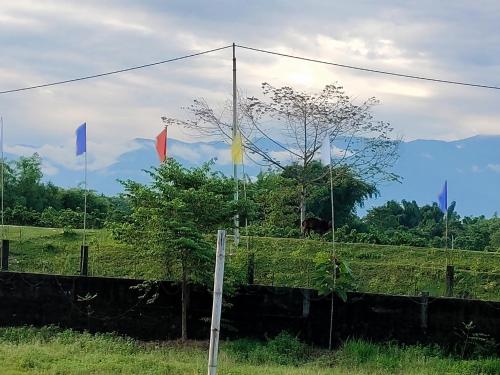 two flags on a fence in a field at Homestay Eco in Jalpāiguri
