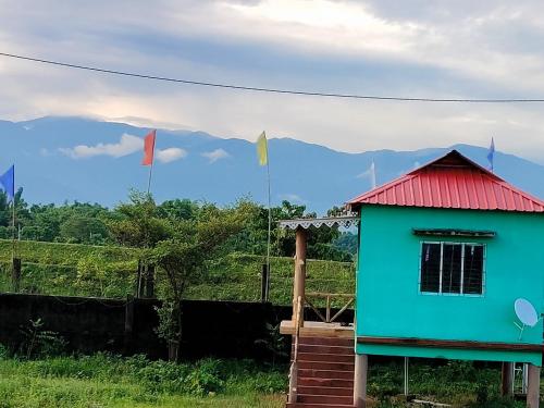 a house with a red roof and flags at Homestay Eco in Jalpāiguri