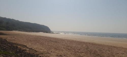 an empty beach with the ocean in the background at Hotel Sushegad in Guhagar